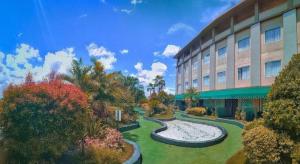 a building with a garden in front of a building at Grand Qin Hotel Syariah in Martapura