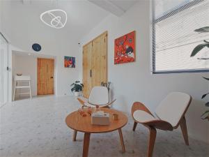 Suzhou Xugusu B&B-Guanqian Street Pingjiang Road Branch في سوتشو: غرفة معيشة مع كرسيين وطاولة