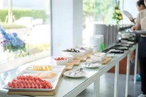 a buffet line with plates of food on a table at Veethara boutique hotel in Udon Thani