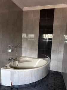 a bathroom with a bath tub in a room at My Home Suites Area14 in Lilongwe