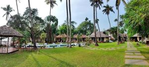 a resort yard with a swimming pool and palm trees at Les 3 Elephants in Cherai Beach