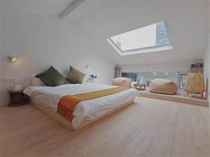 Suzhou Xugusu B&B-Guanqian Street Pingjiang Road Branch في سوتشو: غرفة نوم بيضاء مع سرير ونور