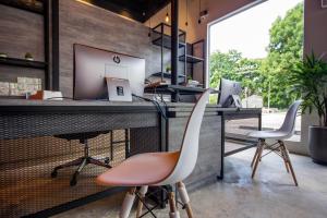 a bar with two chairs and a desk with a computer at Chariton Hotel Alma in Bukit Mertajam