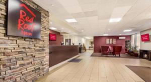 una hall con un cartello rosso per la locanda su un muro di mattoni di Red Roof Inn Winchester - Lexington East a Winchester