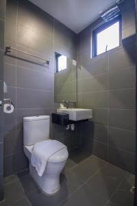 a bathroom with a toilet, sink, and shower stall at Chariton Hotel Alma in Bukit Mertajam