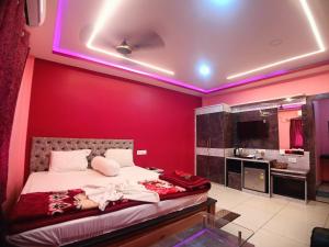 a bedroom with a red wall with a bed and a bathroom at Chuti Beach Resort in Mandarmoni