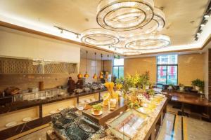 Qilinmenibis Styles Nanjing Qilin Gate Hotel的宽敞的厨房里摆放着一张长桌和自助餐台。