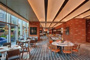 un ristorante con tavoli, sedie e finestre di Hyatt Centric The Ring Chengdu a Chengdu