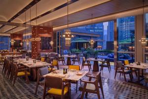 un ristorante con tavoli e sedie e una grande finestra di Hyatt Centric The Ring Chengdu a Chengdu Altre 15 foto