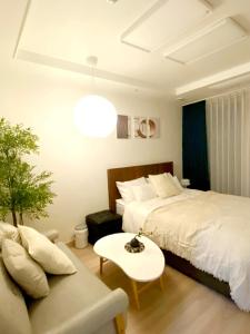 a hotel room with a bed and a couch at 속초 오션뷰 써밋베이1205 in Sajin