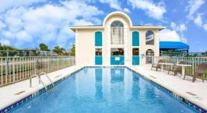 una casa con piscina di fronte a un edificio di Days Inn by Wyndham Apopka/Orlando a Orlando Altre 27 foto