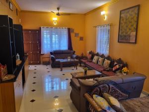 een woonkamer met twee banken en een tv bij Loto Villa in Bangalore