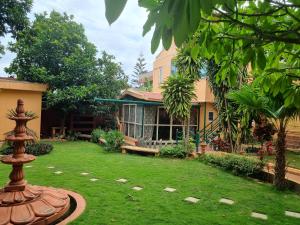 een huis met een tuin met een fontein ervoor bij Loto Villa in Bangalore