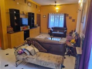 een woonkamer met twee banken en een tv bij Loto Villa in Bangalore
