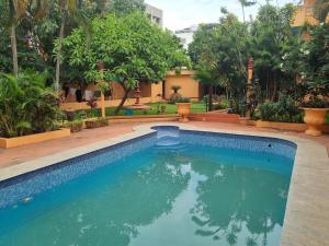 een zwembad in een tuin met bomen bij Loto Villa in Bangalore