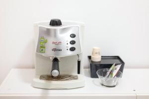 Adua Luxury Apartment في تارانتو: كان هناك صانع قهوة أبيض يجلس على رأس العداد