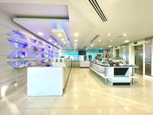 eine große Küche mit weißen Arbeitsflächen und lila Beleuchtung in der Unterkunft Glacier Hotel Khon Kaen in Ban Si Than + 215 Fotos