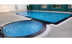 a large swimming pool with blue water in a building at Exotic resort -basai Kashipur ramnagar road in Gaushala