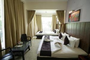 a hotel room with a large bed and a table at Exotic resort -basai Kashipur ramnagar road in Gaushala