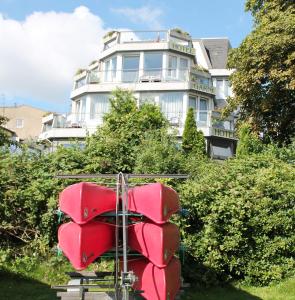 um edifício com mobiliário vermelho em frente em Hotel Wakenitzblick em Lübeck