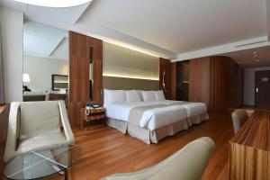 Un dormitorio con una gran cama blanca y una silla. en Pacific Hotel, en Seúl 41 fotos más