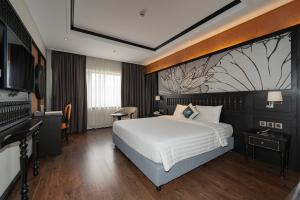 ein Hotelzimmer mit einem Bett und einem Fernseher in der Unterkunft Green Dragon Boutique Hotel in Cẩm Phả + 43 Fotos