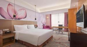 a bedroom with a large white bed and a desk at Yueyang Grand Skylight Hotel in Yueyang +286 photos