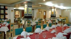 uma sala de jantar com mesas e cadeiras com guardanapos brancos em Hotel Tower Inn, Chittagong em Chittagong Port