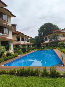 an image of a swimming pool in front of a house at Navilehomestay in Candolim +7 photos