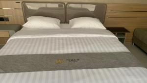 uma cama grande com dois travesseiros em cima em di Turgo Village em Balong