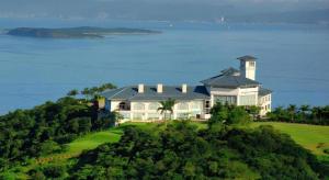 ein großes Haus auf einem Hügel neben dem Meer in der Unterkunft The Century Seaview Hotel in O-kung