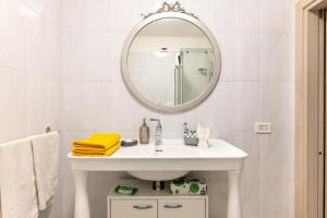 Adua Luxury Apartment في تارانتو: حمام مع حوض أبيض ومرآة +19 صورة