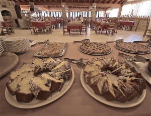 une table recouverte de différents types de pain sur les assiettes dans l'établissement Hotel Masseria Le Pajare, à Presicce