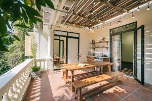 an outdoor patio with a wooden table and benches at Glass Apartment With Big Balcony in Hanoi