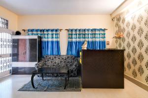 a living room with a chair and a table at FabHotel Samanta in kolkata +19 photos