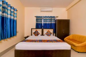 a bedroom with a bed and a chair at FabHotel Samanta in kolkata