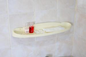 a bathroom with a shelf on a tiled wall at DD House Apartment in Bangkok