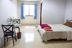 a bedroom with a bed and a table and a window at DD House Apartment in Bangkok