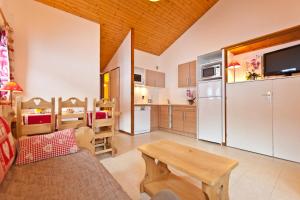 a kitchen and living room with a couch and a table at Résidence Azureva La Clusaz les Aravis in La Clusaz