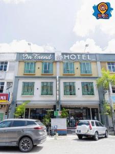 2 auto parcheggiate di fronte a un hotel di In Trend Hotel a Kampong Nipah Panjang