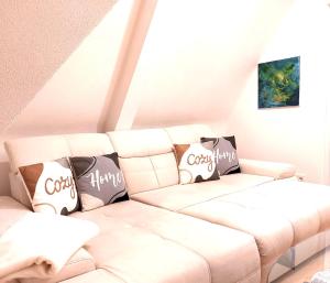a living room with a white couch with pillows at Traumhaftes Apartment mit Dachterrasse und Schlossblick in Marburg an der Lahn