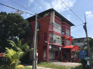 ein rotes Gebäude an der Ecke einer Straße in der Unterkunft OYO 89653 Anisaa Inn in Kampong Pengkalan Dopah