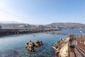 a body of water with rocks in the water at Janghohang Ilmare Pension in Samcheok +11 photos