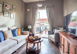 a living room with a couch and a tv at LohonoStays Villa Beleza C in Oxel