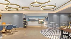 uma sala de estar com um lustre e mesas e cadeiras em Magnotel Harbin Medical University First Affiliated Hospital em Harbin