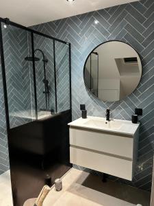 un baño con lavabo y espejo en Au Papillon, en Magenta