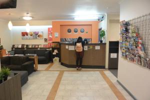 a woman standing at a counter in a store at Elizabeth Hostel in Melbourne