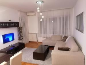 a living room with a couch and a tv at Apartman 44, sa garažom, Mejdan Banja Luka in Banja Luka