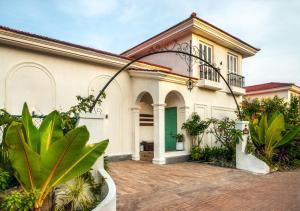 a house with a green door and some plants at LohonoStays Villa Beleza C in Oxel