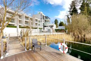 una terrazza in legno con panca e un edificio di Seehotel Forst a Forst